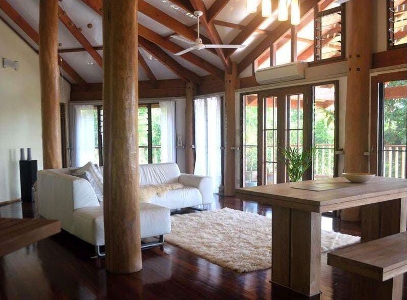 A Living Room With a White Couch and a Wooden Table — Coral Coast Building & Management in Cannon Valley, QLD