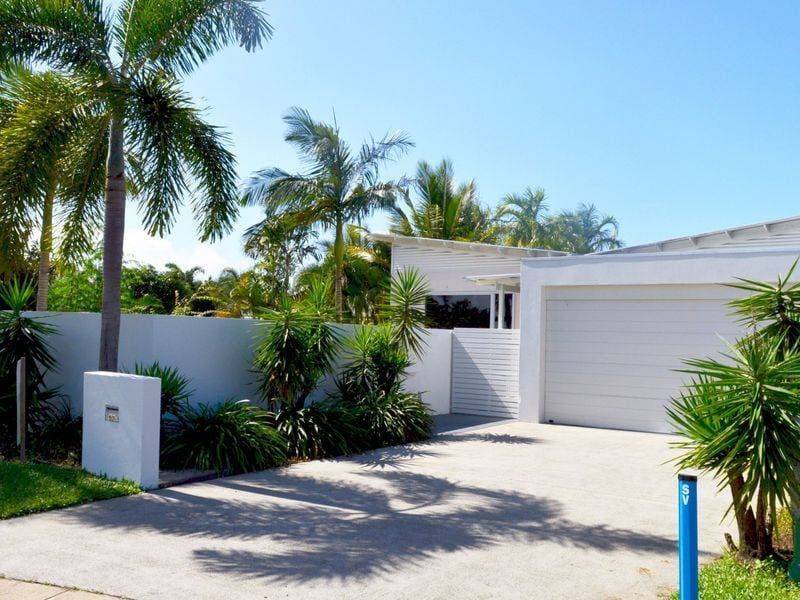 A White House With a Blue Pole in Front of It — Coral Coast Building & Management in Cannon Valley, QLD