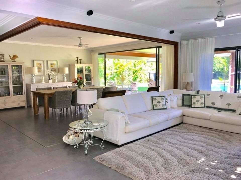 A Living Room With a White Sectional Couch and a Rug — Coral Coast Building & Management in Cannon Valley, QLD