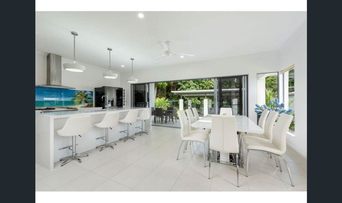 A Kitchen and Dining Room in a House With a Long Table and Chairs — Coral Coast Building & Management in Cannon Valley, QLD