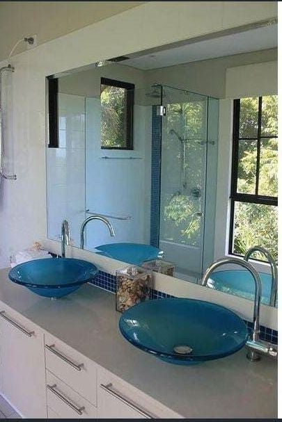 A Bathroom With Two Blue Sinks and a Large Mirror — Coral Coast Building & Management in Cannon Valley, QLD
