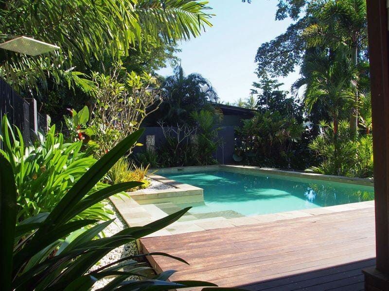 A Large Swimming Pool Surrounded by Trees and Plants — Coral Coast Building & Management in Cannon Valley, QLD