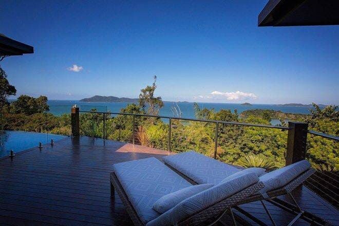 There Are Two Lounge Chairs on the Deck Overlooking the Ocean — Coral Coast Building & Management in Cannon Valley, QLD