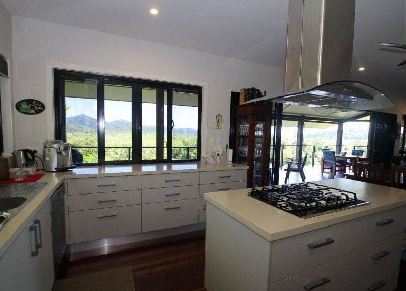 A Kitchen With a Large Island and a Stove Top Oven — Coral Coast Building & Management in Cannon Valley, QLD