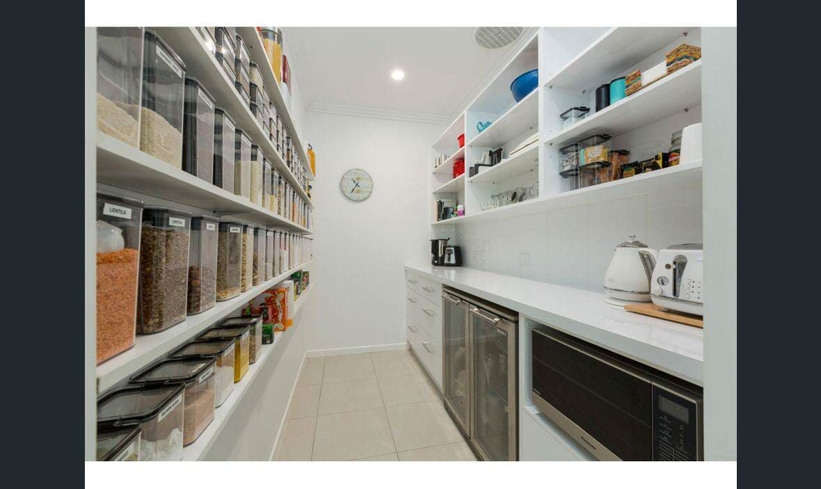 A Kitchen With Lots of Shelves and a Microwave — Coral Coast Building & Management in Cannon Valley, QLD