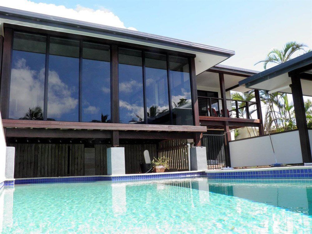 A Large House With a Swimming Pool in Front of It — Coral Coast Building & Management in Cannon Valley, QLD