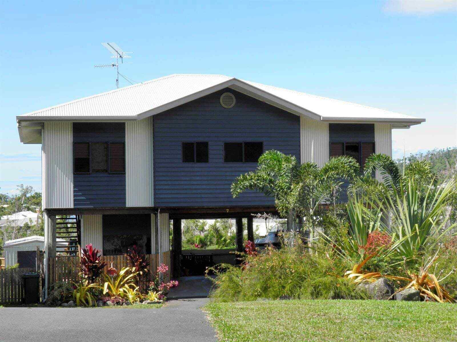 A Large House With a White Roof and a Driveway — Coral Coast Building & Management in Cannon Valley, QLD