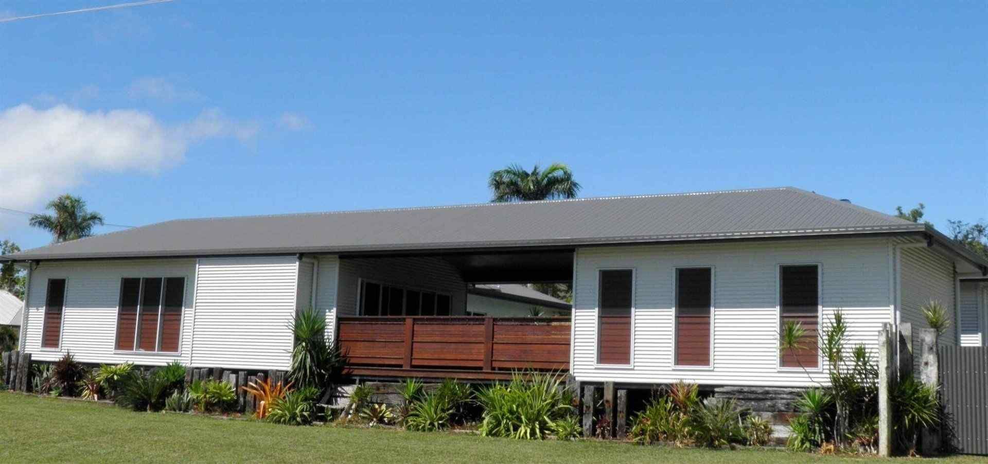A White House With a Gray Roof and a Wooden Deck — Coral Coast Building & Management in Cannon Valley, QLD