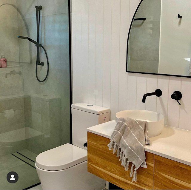 A Bathroom With a Toilet a Sink and a Mirror — Coral Coast Building & Management in Cannon Valley, QLD