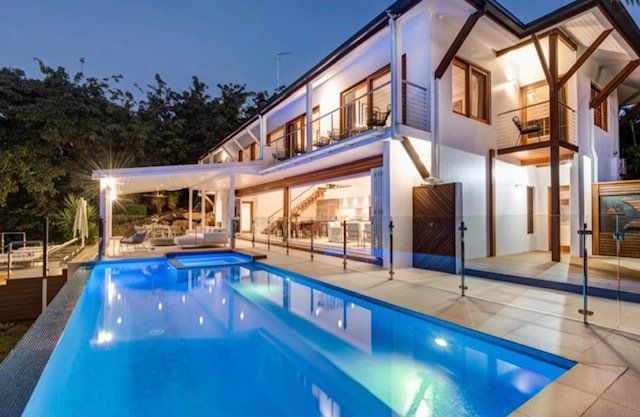 A Large House With a Large Swimming Pool in Front of It — Coral Coast Building & Management in Cannon Valley, QLD