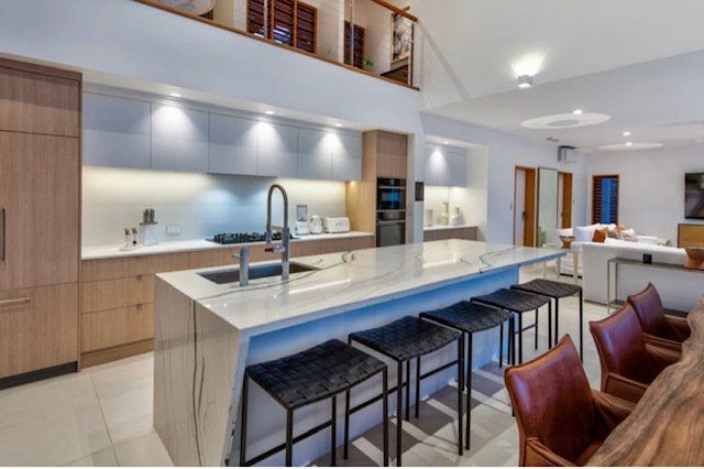 A Kitchen With a Large Island and Stools — Coral Coast Building & Management in Cannon Valley, QLD