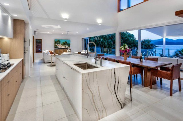 A Kitchen With a Large Island and a Dining Table — Coral Coast Building & Management in Cannon Valley, QLD