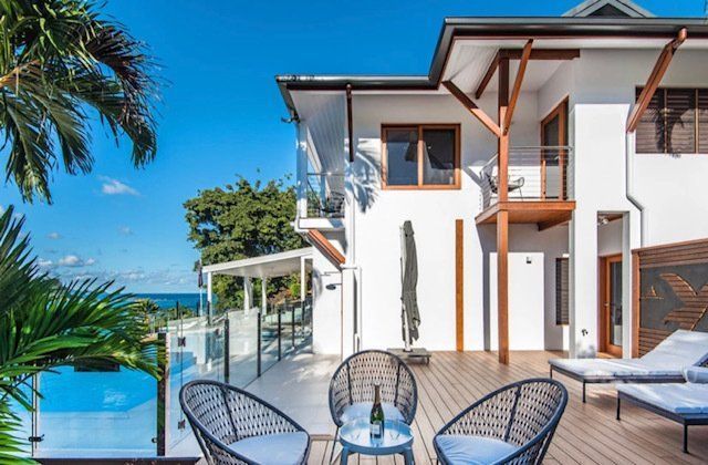 A Large White House With a Swimming Pool in Front of It — Coral Coast Building & Management in Cannon Valley, QLD