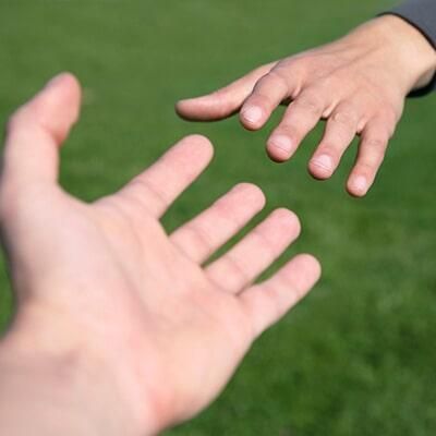 Una persona extiende su mano para ayudar a otra persona.