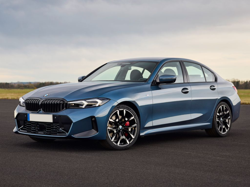 Berlina BMW blu su strada asfaltata, di giorno.