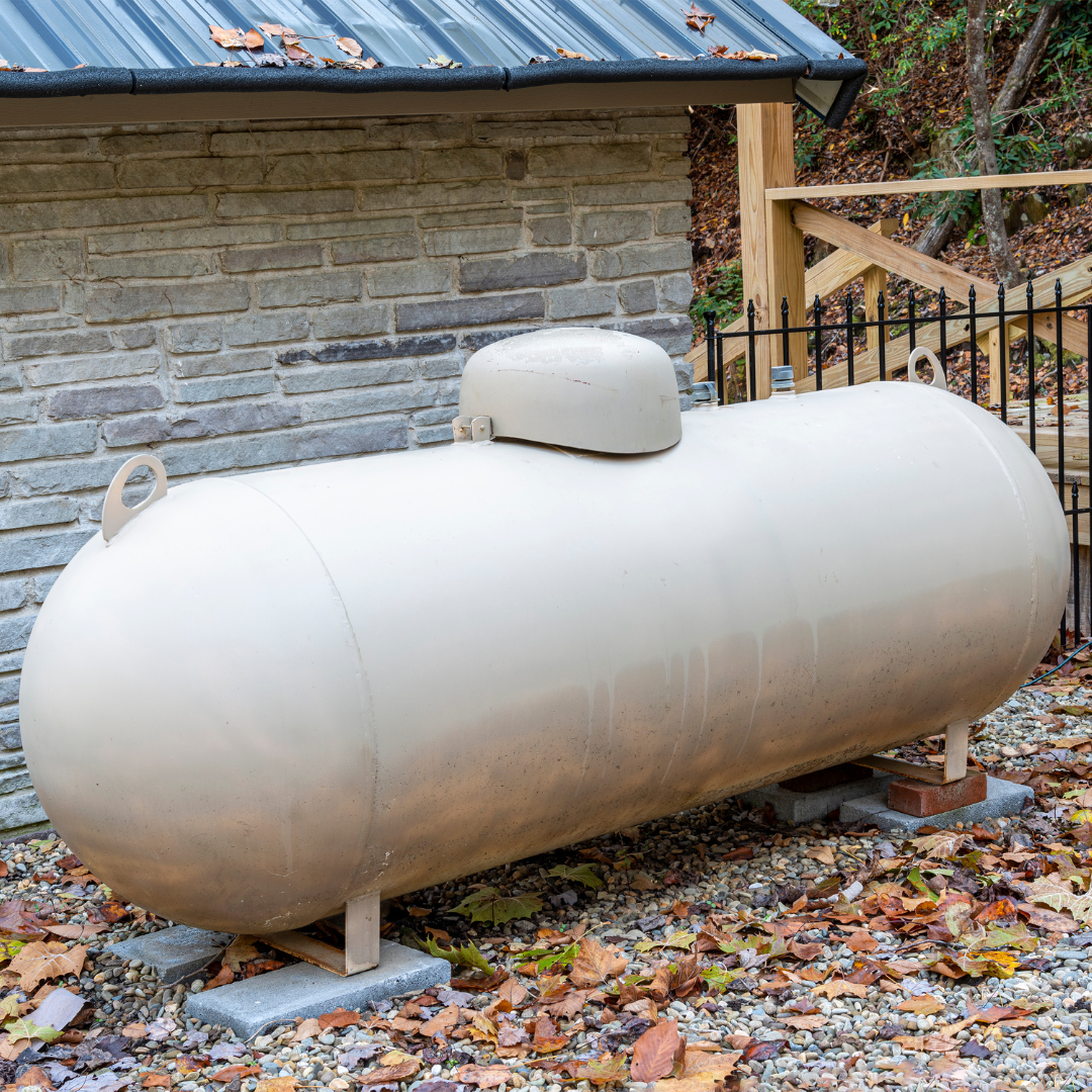 a large propane tank sits outside of a brick building