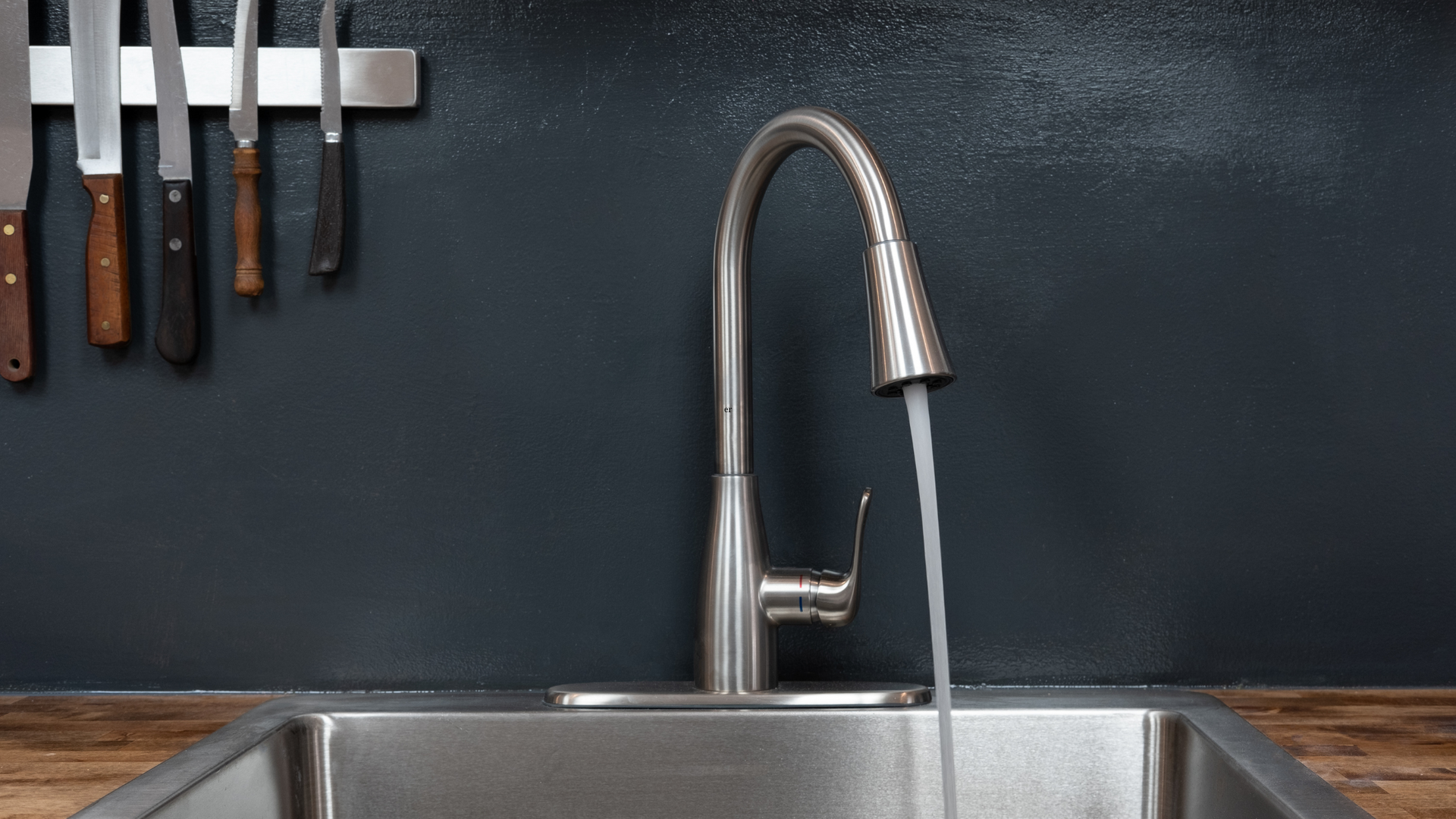 a stainless steel kitchen sink with water running from the faucet