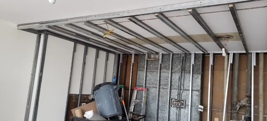 A man is standing in a room with a ladder.