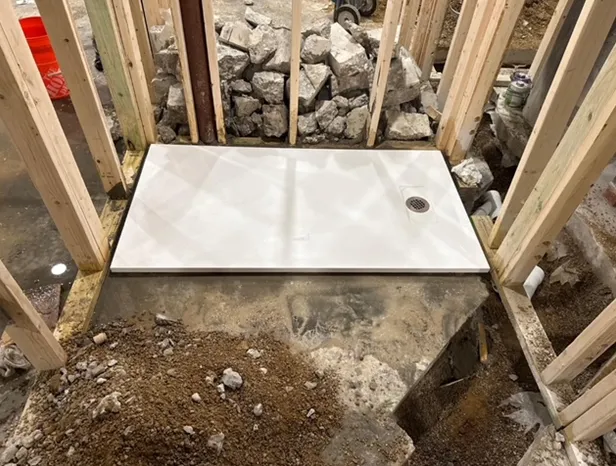 A shower stall is being built in a basement.