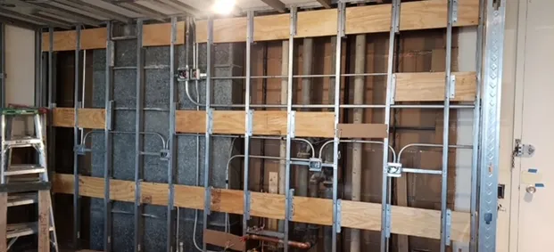 A room with a wooden wall and a metal frame.