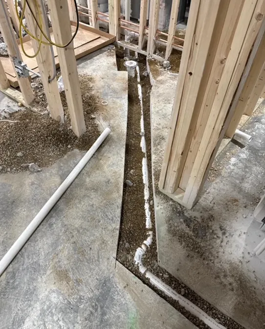 A drain is being installed in the floor of a building under construction.