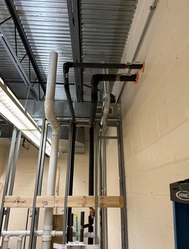 A room with a lot of pipes hanging from the ceiling.