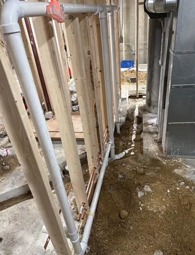 A row of pipes are being installed in a building under construction.