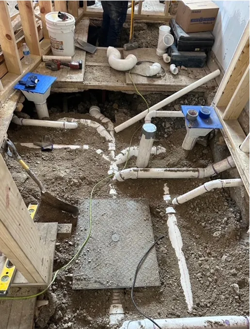 A bunch of pipes are laying on the ground in a room.