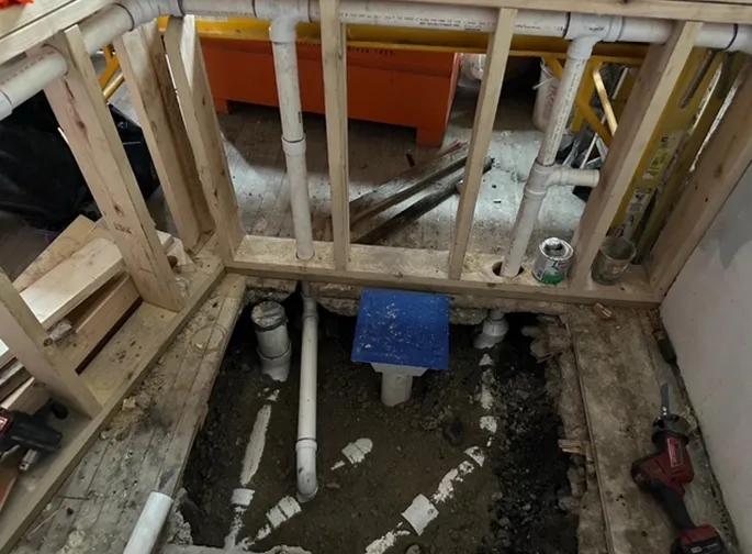 A hole in the floor with pipes coming out of it