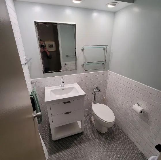 A bathroom with a sink , toilet and mirror.