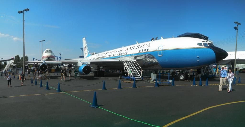 A blue and white airplane is parked in a parking lot