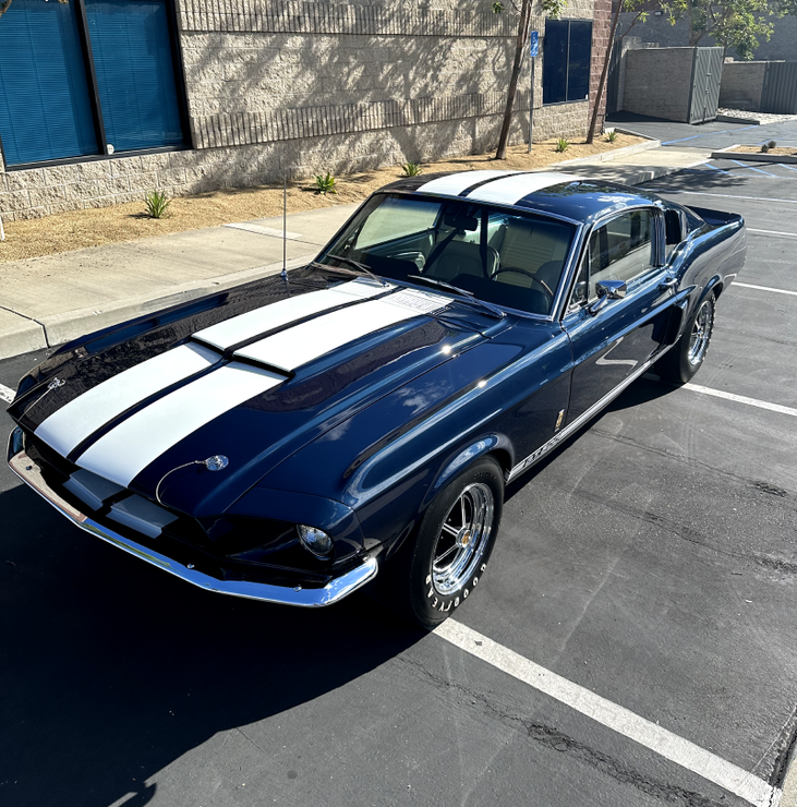 a black and white mustang is parked in a parking lot .