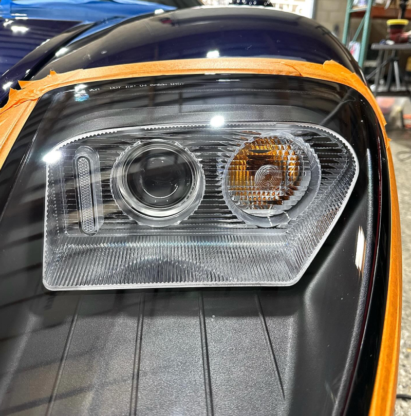 A close up of a car headlight with tape on it