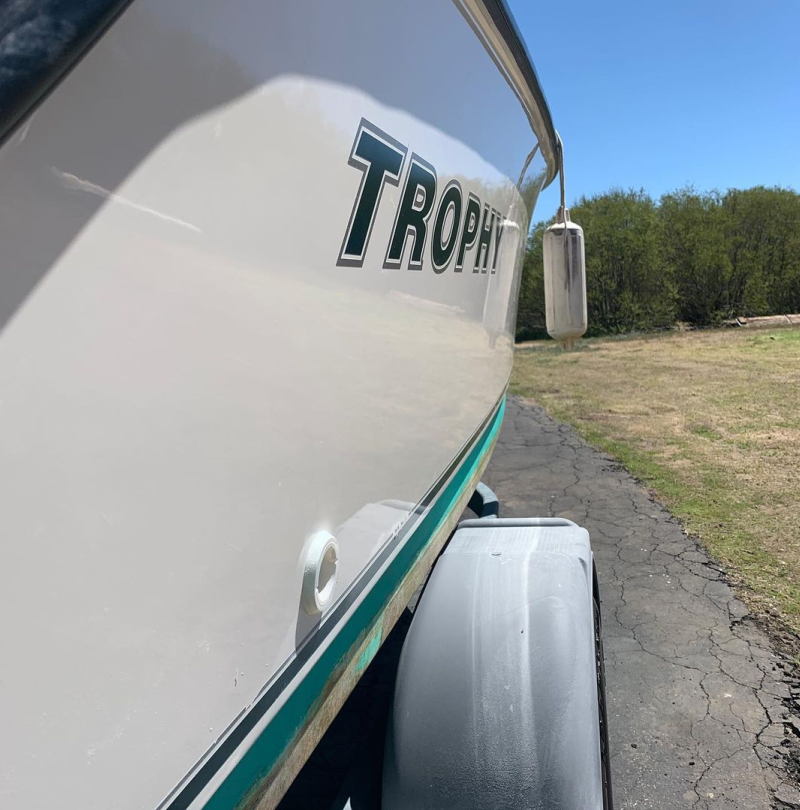 A white boat with the word trophy on the side