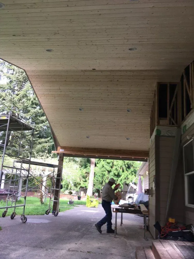 A man is working on the ceiling of a house.