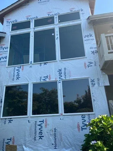 A house with a lot of windows is covered in styrofoam.