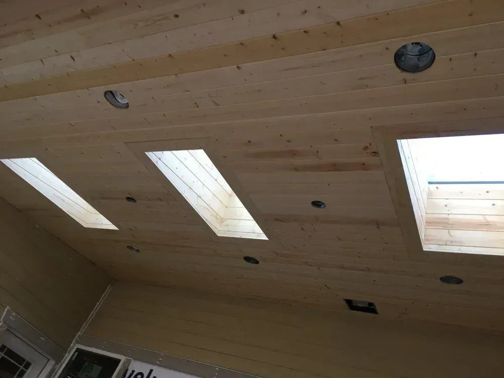 A wooden ceiling with three skylights on it