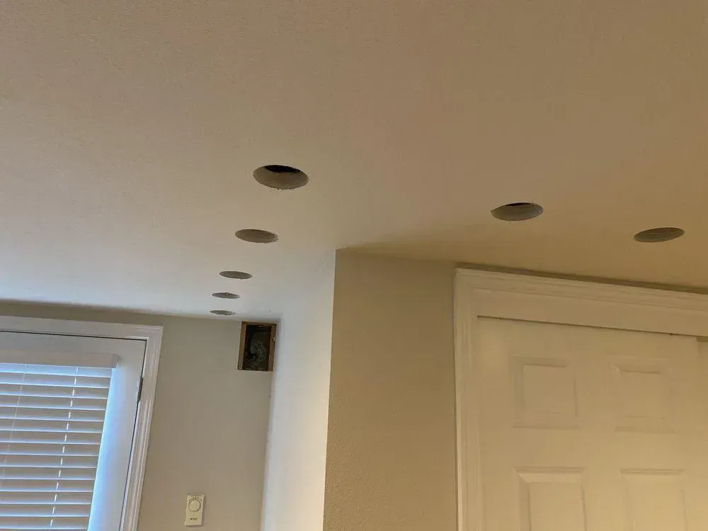 A room with a ceiling that has holes in it and a window.