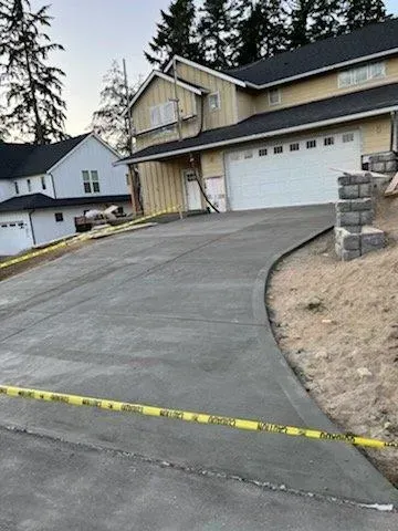 A concrete driveway is being built in front of a house.