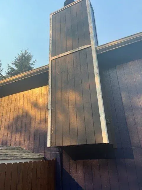 A wooden chimney on the side of a house