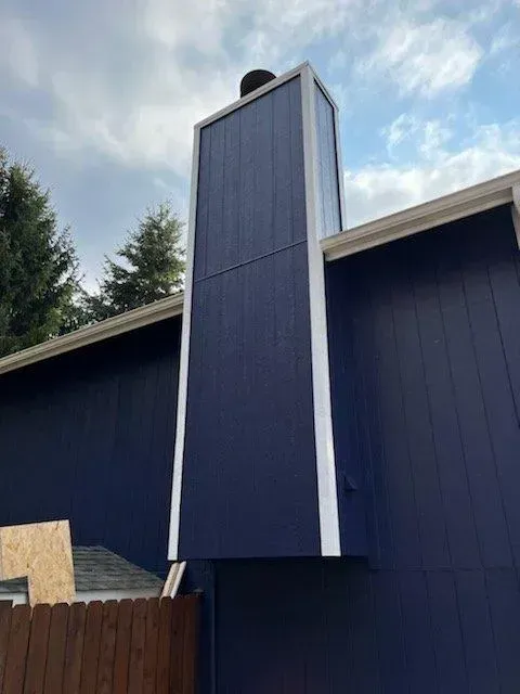 A blue house with a white chimney on top of it