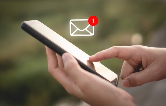 Hand holding a smartphone with an email notification icon, indicating one unread message.