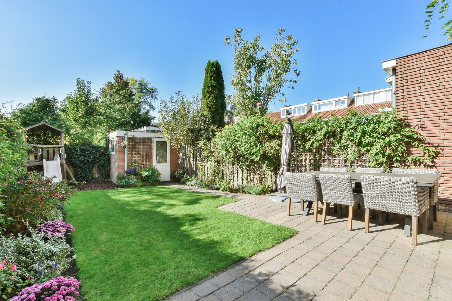 There is a patio with a table and chairs in the backyard.