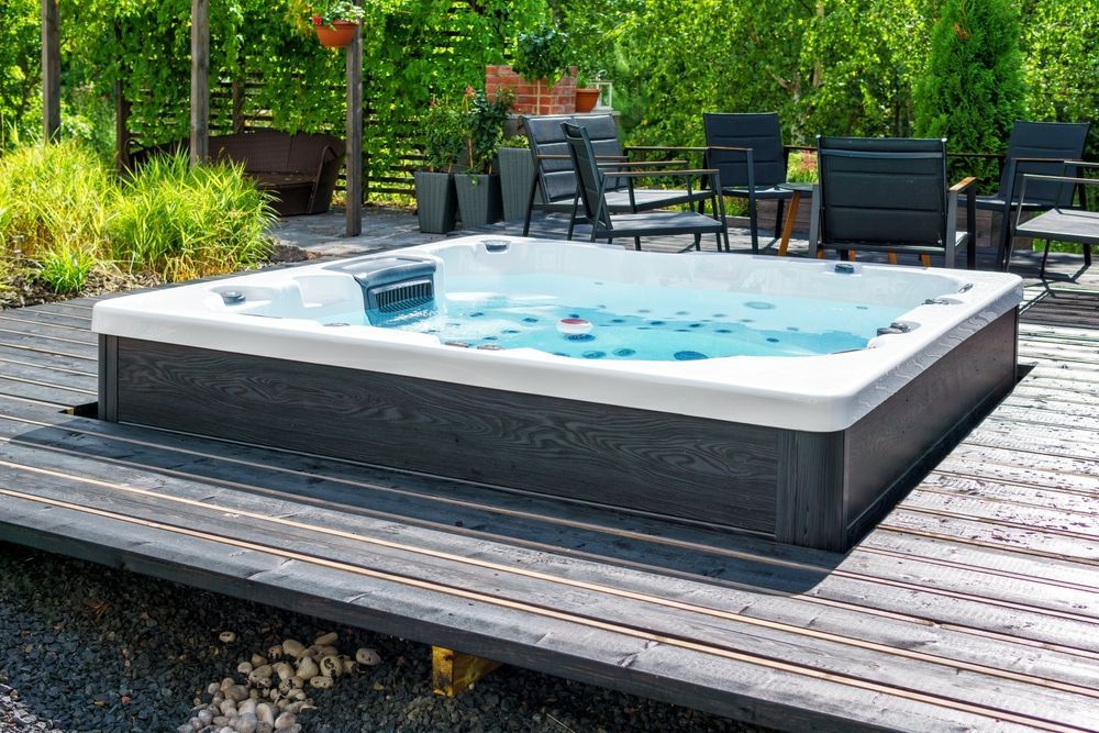 A hot tub is sitting on top of a wooden deck.