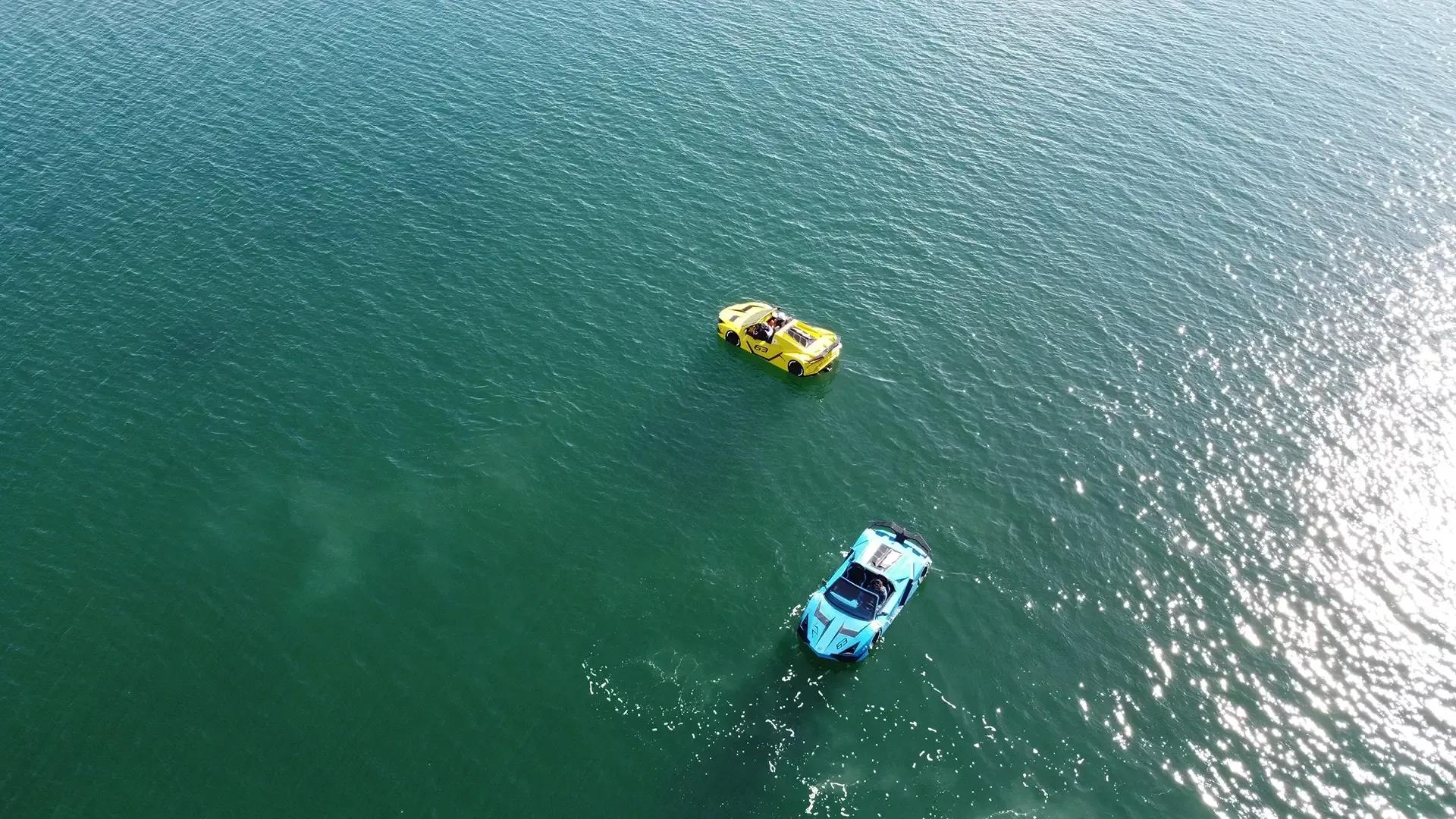 An aerial view of two boats floating on top of a lake.