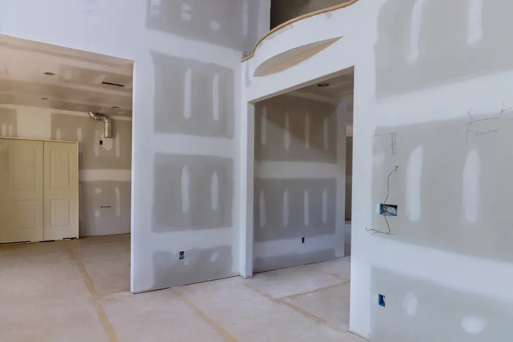 Interior view of a building under construction, showing drywall walls, doorways, and unfinished surfaces in Huntley, IL