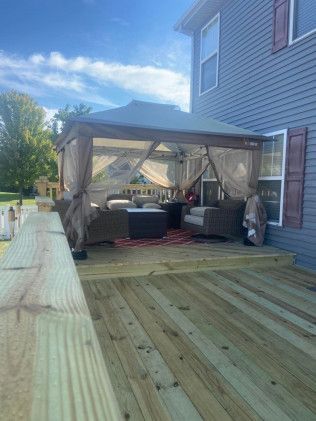 There is a pergola on the deck of a house in Lindenhurst, IL.