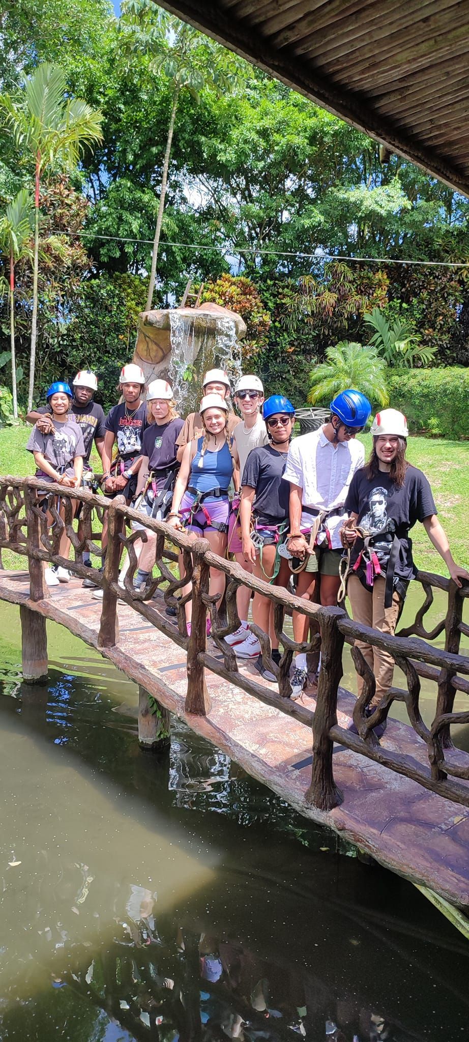 A group of people are walking across a wooden bridge over a body of water.
