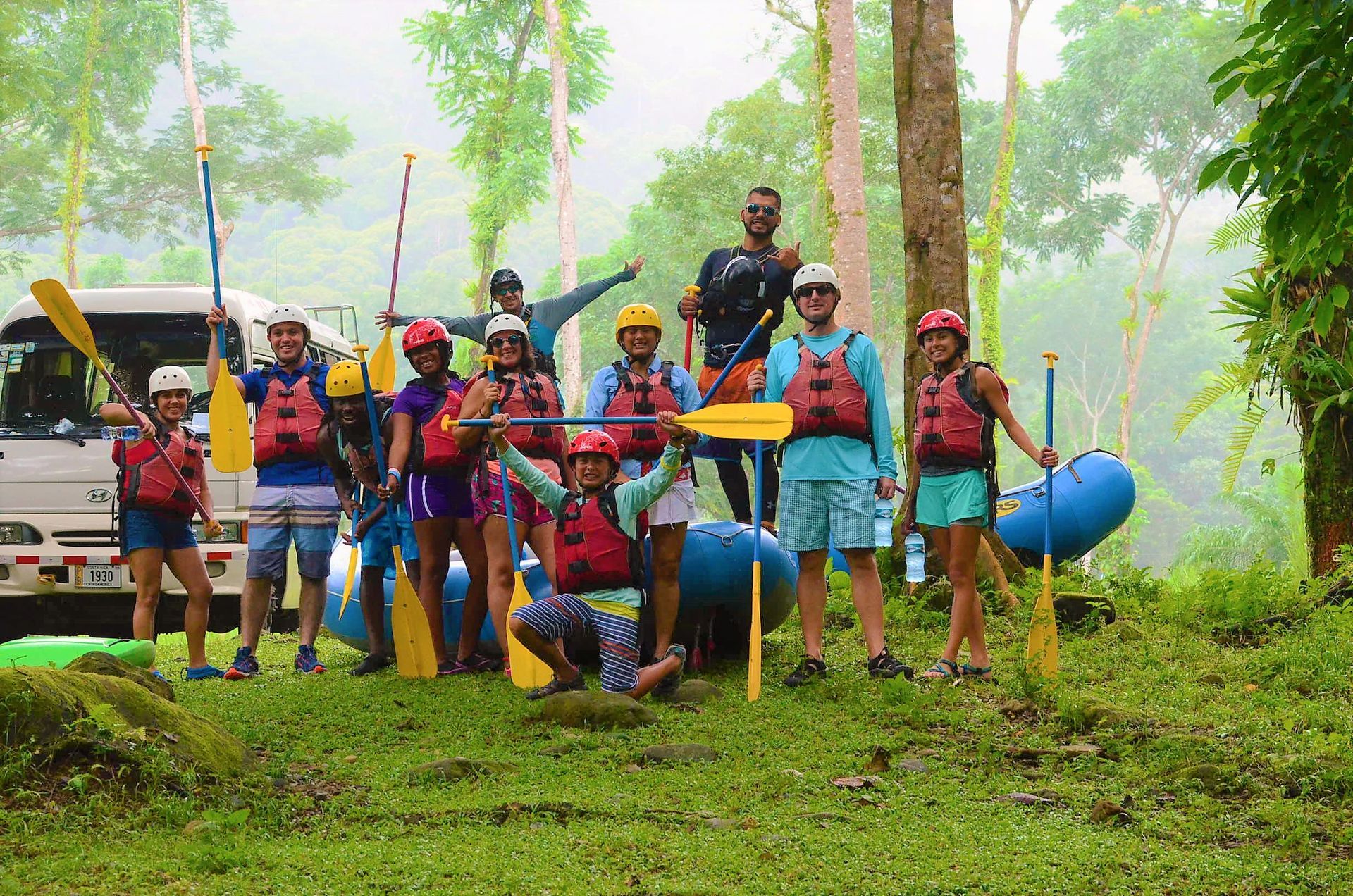 A group of people are posing for a picture in front of a raft.