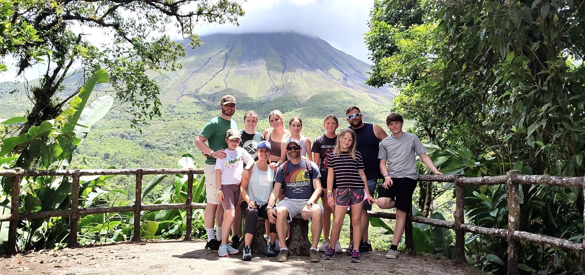 A group of people are posing for a picture in front of a mountain.